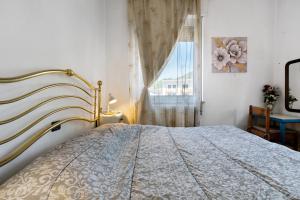 a bedroom with a bed and a window at Casa Rosa in Levico Terme