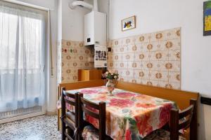 a dining room table with a vase of flowers on it at Casa Rosa in Levico Terme