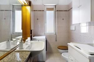 a white bathroom with two sinks and a toilet at Casa Rosa in Levico Terme +25 photos