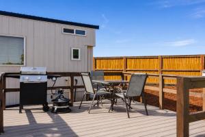 a patio with a table and chairs on a deck at Near Zion Modern Tiny Home Hiking & MTB Access in Apple Valley