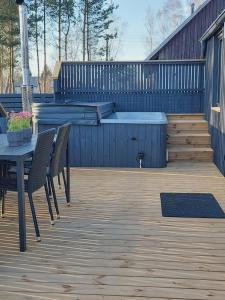 a patio with a table and chairs and a hot tub at Trijų namelių uostas in Dreverna