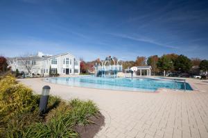 a large swimming pool in front of a house at The Colonies at Williamsburg in Williamsburg