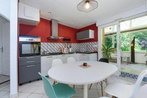 a kitchen and dining room with a white table and chairs at Domaine des légendes in Plumelin