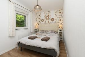 a bedroom with a bed with towels on it at Domaine des légendes in Plumelin