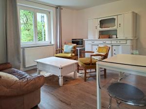 a living room with a couch and chairs and a table at Villa Amselgrund in Rathen