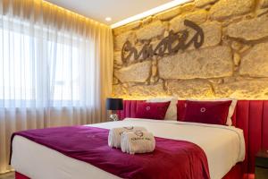 a bedroom with a large bed with a stone wall at Lounge Inn Guest House in Porto