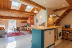 a kitchen and living room with wooden ceilings at Élégant T3 Terrasse & Wifi in Vals-les-Bains +13 photos