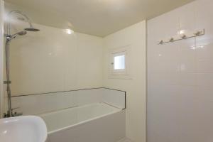 a white bathroom with a shower and a sink at Élégant T3 Terrasse & Wifi in Vals-les-Bains