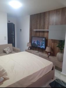a bedroom with a bed and a flat screen tv at CoCo Nest Cozy Modern Studio Near Mamsha Beach & Airport in Hurghada