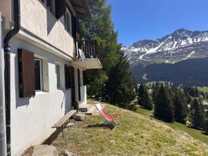 a house with a bench on the side of a mountain at Chalet Vallese Valbella Lenzerheide, great view in Valbella