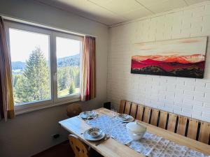 a dining room with a table and two windows at Chalet Vallese Valbella Lenzerheide, great view in Valbella
