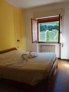 a bedroom with a bed with two towels on it at Vittoria 1920 - hotel restaurant apartaments in Marzio