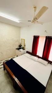 a bedroom with a large bed and red curtains at Olive Homestay in Cochin