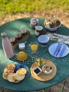 a green table with plates of food on it at Le nid du Curtil - Chambre d'hôtes in Rougegoutte