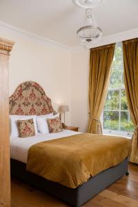 a bedroom with a bed and a chandelier at Bishop's Gate Hotel in Derry Londonderry +90 photos