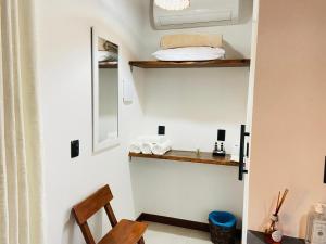 a room with a chair and a mirror and towels at Jardim dos Milagres Suítes in São Miguel dos Milagres +61 photos