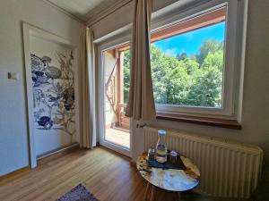 a room with a table and a large window at GRÜNER HEINRICH - Bett&Frühstück in Oberaichwald
