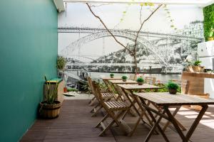 a patio with tables and chairs in front of a bridge at Lounge Inn Guest House in Porto