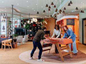 a group of people playing a game with a table at Aparthotel Adagio Stuttgart NeckarPark in Stuttgart