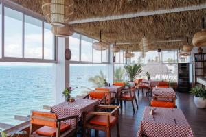a restaurant with tables and chairs and the ocean at ZAN Island Beach in Jambiani
