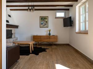 a living room with a table and a tv at Villa Maslina in Novalja