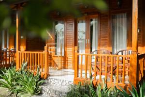 a wooden house with chairs on the front porch at Kamasan Nusa Penida By Reccoma in Nusa Penida +96 photos