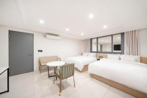 a hotel room with two beds and a table at Rium Hotel in Mokpo