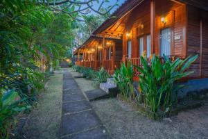 a pathway next to a wooden house with plants at Kamasan Nusa Penida By Reccoma in Nusa Penida