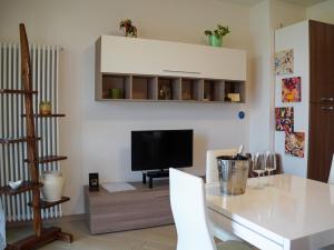 a living room with a table and a television at New Home Lazise in Lazise
