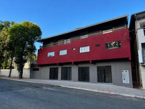 a red building on the side of a street at Pousada Estação Rio Branco in Votuverava