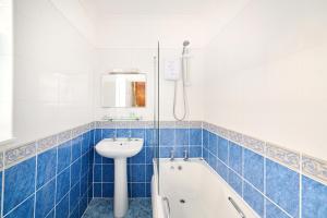 a blue tiled bathroom with a sink and a tub at The Atherstone Red Lion Hotel in Atherstone +58 photos
