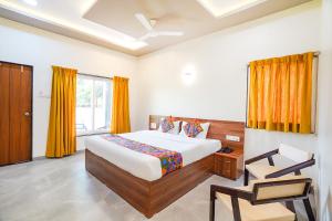 a bedroom with a bed and a chair in it at FabHotel Nakshtra Resort in Tāsgaon +52 photos