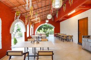 a dining room with tables and chairs and red walls at FabHotel Nakshtra Resort in Tāsgaon