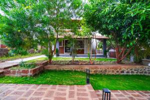 a yard with a house with trees and a bench at FabHotel Nakshtra Resort in Tāsgaon