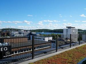 a fence with a view of a city at Syke Apartment Jyväskylä in Jyväskylä