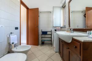a bathroom with two sinks and a toilet and a mirror at Casa Villa Aury in Cefalù +25 photos