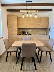 a kitchen with a wooden table and chairs at Villa Maslina in Novalja
