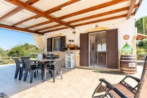 a patio with a table and chairs and a kitchen at Casa Villa Aury in Cefalù