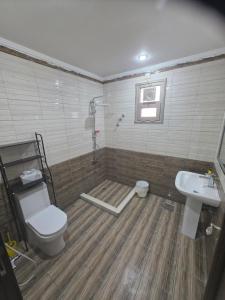 a bathroom with a toilet and a sink at Khiran City in An Nāmī