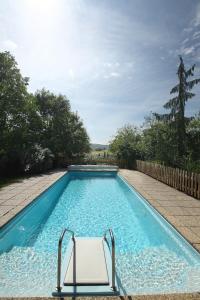 a swimming pool with a chair in a yard at Landhotel Schwabenhof in Heiligenbrunn