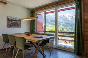 a dining room with a table and chairs and a large window at Chalet Ravenstein in Fiesch +38 photos