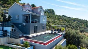 a house with a swimming pool in the backyard at Villa Franka by Villas Guide in Vela Luka