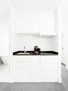 a kitchen with white cabinets and a sink at Vins de Dagne in Montlaur +70 photos