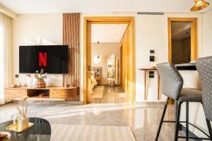 a living room with a tv and a table at The Iconic Spot - Pool and Sea View in Anfa-Supérieur