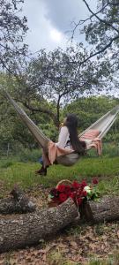 a woman laying in a hammock next to flowers at Glamping sin salir de la CDMX in Mexico City