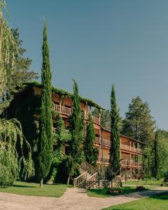 a building with trees and stairs in front of it at Lopota Lake Resort & Spa in Napareuli