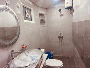 a bathroom with a tub and a toilet and a sink at Soar Serenity Homes in Pithorāgarh
