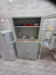 a kitchen with white cabinets and a table and a refrigerator at Khiran City in An Nāmī +14 photos