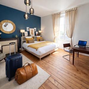 a bedroom with a bed and a suitcase at Le Clos Gabrielle in Châtellerault