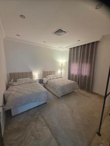 a bedroom with two beds and a window at Khiran City in An Nāmī